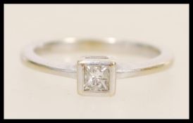 An 18ct white gold solitaire ring set with a square cut with stone to the head. Hallmarked London.