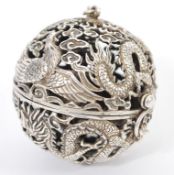 A Chinese silver pierced incense ball having decoration of dragons flames and birds with silver