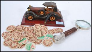 A 20th Century carved wood model of a 1920's soft top car with a varnished finish on a plinth