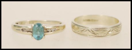 A stamped 375 9ct white gold ring set with an oval cut blue topaz stone with channel set white