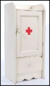 An early 20th Century wall hanging medicine cabinet / First Aid box, the hinged door opening to