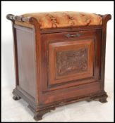 A Victorian mahogany fall front piano stool. The upholstered hinged top over carved panel with