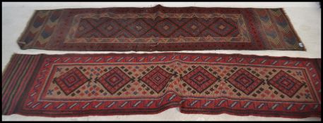 Two early 20th century Persian Middle Eastern carpet runner rugs, both having red ground with