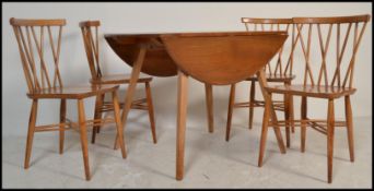 A vintage retro Ercol drop leaf dining table along with a set of four vintage mid 20th Century Ercol