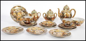 An early 20th century Japanese Meiji period Satsuma part tea service consisting of teapot, creamer