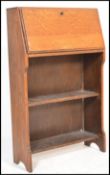 An early 20th Century oak student bureau, fall front with fully appointed interior over open shelved