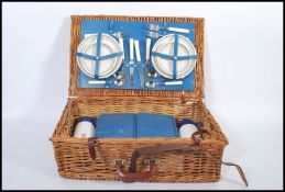 A good quality picnic hamper set to the original wooden wicker basket having leather straps.