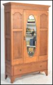 A 20th Century 1920's Edwardian oak wardrobe having a central door with a bevelled oval mirror