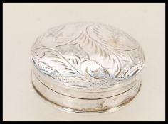 A stamped 925 silver pill box of round form having foliate engraving to the domed lid. Total