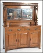 A Victorian oak Arts & Crafts mirror back sideboard having short drawers over cupboard with good