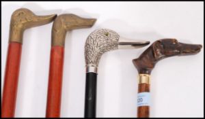 A group of vintage walking stick canes all having figural handles to include a silver plated duck