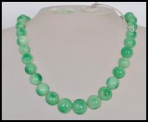 A vintage Chinese green jade prayer bead necklace having a graduating set of round beads and