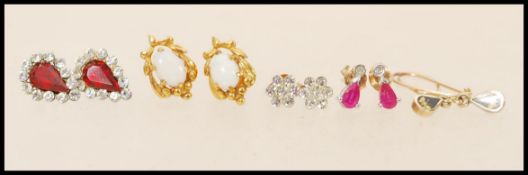 A selection of 9ct gold earrings to include a pair of stud earrings set with opals, a pair of stud