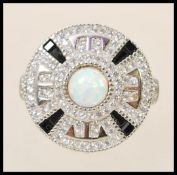 A stamped 925 silver Art Deco style ring with a round head set with a central opal and surrounded by