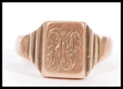 A hallmarked 9ct gold gents signet ring having a monogrammed cartouche and stepped shoulders. Weighs