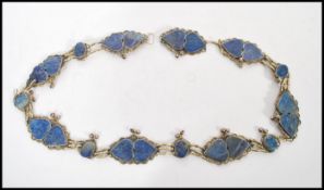 A vintage early 20th century silver white metal belt having lapis / blue stone panels with bell