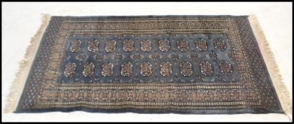 A late 20th century Indian machined carped floor rug having a deep teal blue ground having geometric