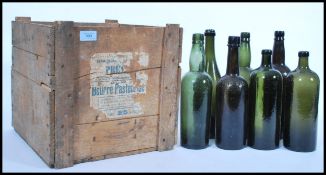 A vintage 19th century wooden shipping crate along with a group of 19th century wine bottles.