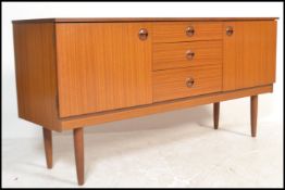 A retro 20th Century teak veneered sideboard, having a central bank of three drawers flanked by