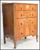 A 1930's Art Deco walnut chest of drawers being raised on cabriole legs with upright bank of drawers