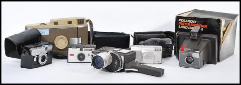 A collection of vintage cameras and accessories to include an early Polaroid Land camera, a Kodak