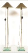 A pair of brass and glass contemporary standard lamps. Each raised on glass terraced bases with