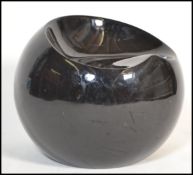 A contemporary 1970's style black gloss fibreglass ball chair having a shaped seat to top in the