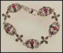 A stamped 925 silver spacer bracelet set with marcasite and rubies. Weight 26.7.