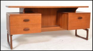 A mid century Donald Gomme for Ernest Gomme G-Plan teak wood writing table desk being raised on