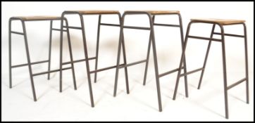 A set of 4 retro 20th century Industrial lab - laboratory stools raised on tubular black metal