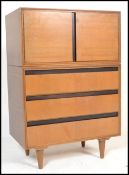 A vintage mid 20th Century walnut veneered tallboy by Merrydew, cupboard doors over three long