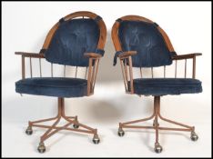 A pair of 20th Century American retro vintage office swivel desk chairs being of metal construction;