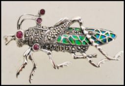 A stamped 925 silver plique a jour brooch in the form of a grass hopper set with rubies to the