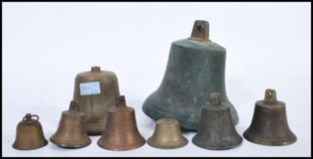 A collection of hanging bronze and brass bells dating from the 19th Century, varying in size with