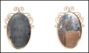 A pair of 20th century copper wall mirrors having scrolled frames with hammered design and central