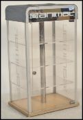 A shop display / counter top revolving illuminated display cabinet having shelves to the interior