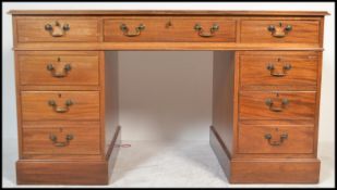 A 20th Century Georgian revival mahogany kneehole twin pedestal writing desk, with inset red leather