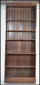 A large early 20th century solid oak library upright bookcase cabinet. Raised on plinth base with