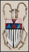 A silver brooch in the form of a beetle / bug having an enamelled back with a geometric pattern.