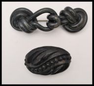 A circa 19th century Victorian vulcanite brooch together with a carved jet brooch. Largest