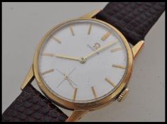 A vintage 20th century Omega wrist watch having a silvered dial with gilt baton numerals and cross