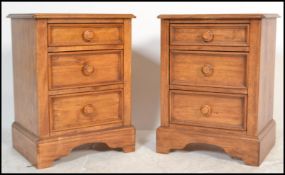 A pair of contemporary hardwood bedside chests of drawers, each raised on a plinth base with a