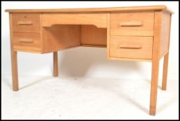 A vintage retro 20th century Abbess oak office industrial desk raised on block legs with two
