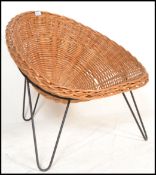 An original retro 20th century wicker tropics chair / armchair raised on a tripod hairpin leg