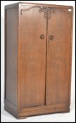 A 1930's Art Deco oak bachelors wardrobe with full length panel door having central embellishment.