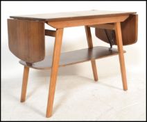 A vintage retro 20th Century double drop flap coffee table, raised on splayed tapering supports