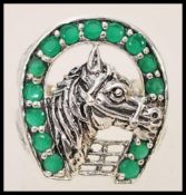 A stamped 925 silver ring in the form of a horseshoe with a horse to the centre set with green