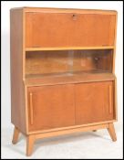 A vintage retro 20th century teak bureau raised on angular legs with sliding glass and wooden doors.