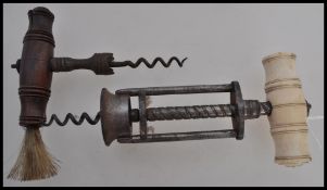 Two Georgian corkscrews to include one carved bone handle with a metal brace below along with a