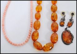A selection of amber type jewellery to include a beaded necklace, a marked 925 silver pendant set